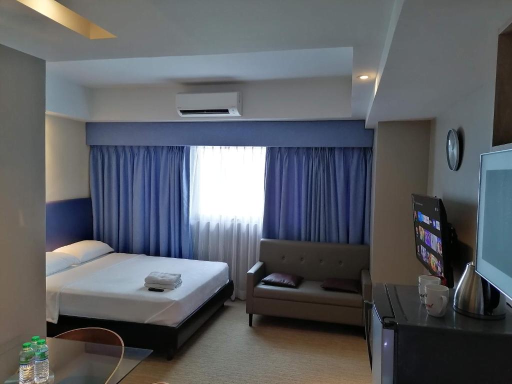 a hotel room with a bed and a window at Studio Deluxe @ Sta.Lucia East Grand Mall - Hotel & Residences in Manila