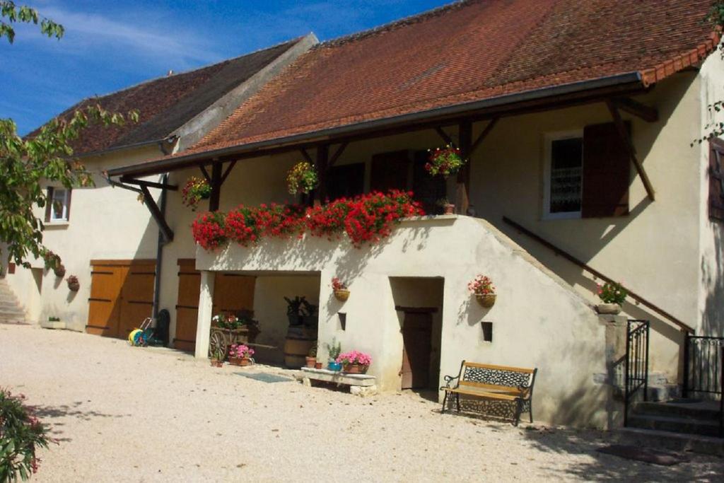 Biały dom z kwiatami na boku w obiekcie le Chaumois w mieście Saint-Boil