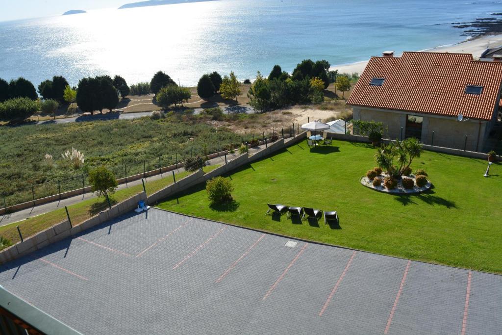 an overhead view of a parking lot with chairs and the ocean at Apartamentos Rozas Vellas in Sanxenxo