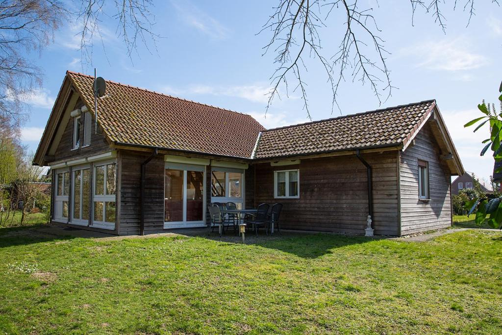 a small wooden house with a grass yard at Haus Janina in Rieste