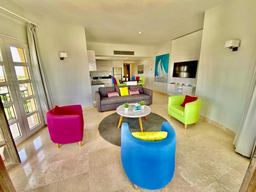 El Gouna Abu Tig Marina OV3550 في الغردقة: غرفة معيشة مع كراسي ملونة وطاولة