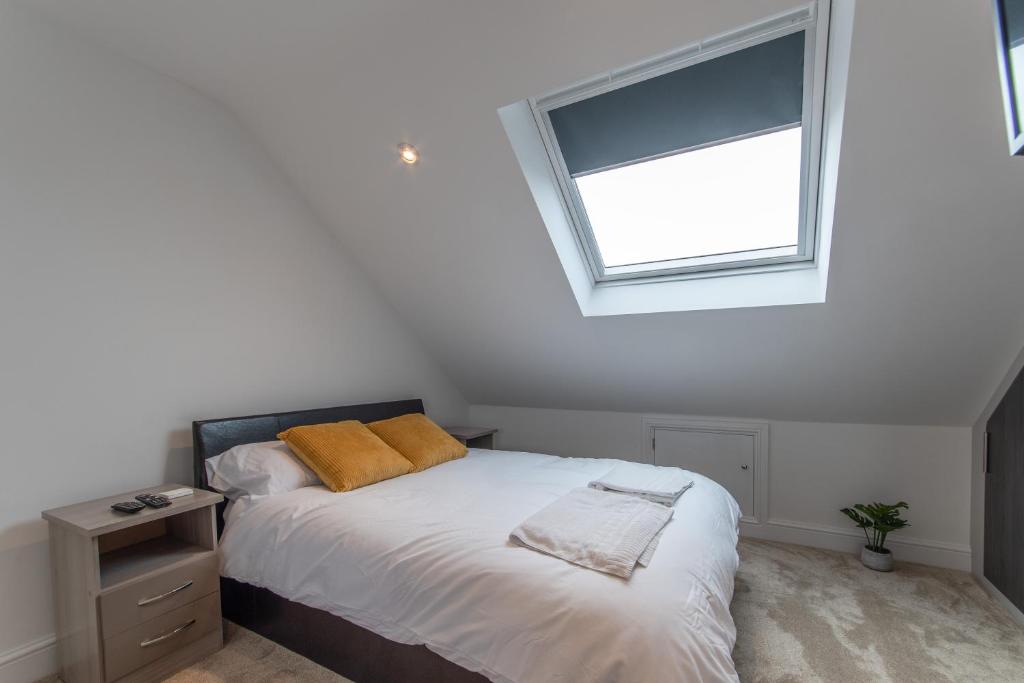 1 dormitorio con cama y ventana en Super cosy self-catering studio flat, en Gillingham