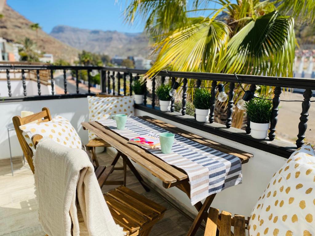 een tafel en stoelen op een balkon met planten bij Harrys Apartment 2 by SunHousesCanarias in Puerto de Mogán