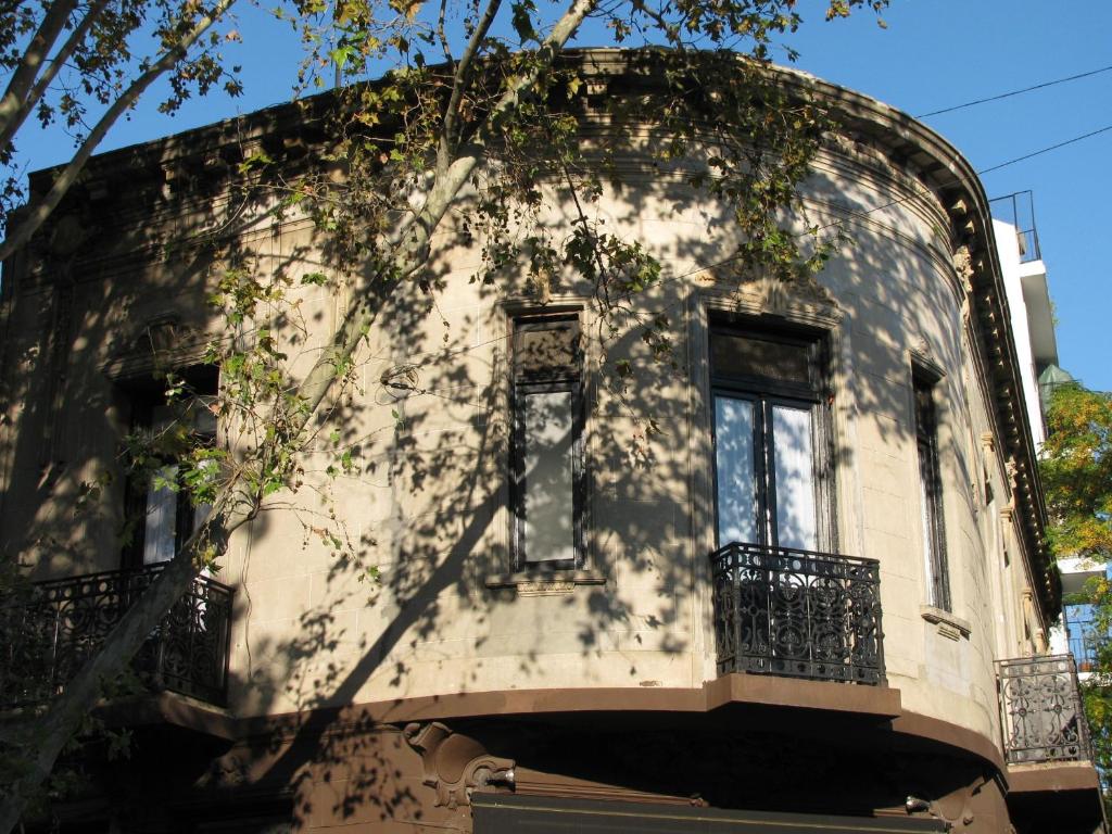 un edificio antiguo con una ventana y un árbol en 06 Soho Suites en Buenos Aires