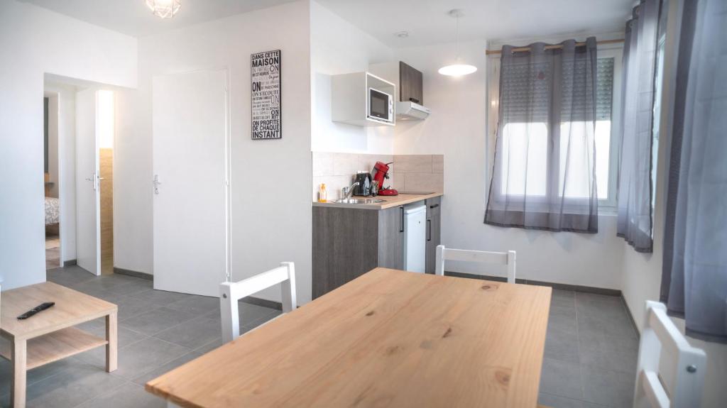 eine Küche mit einem Holztisch und einem Esszimmer in der Unterkunft Git'appart in Airaines