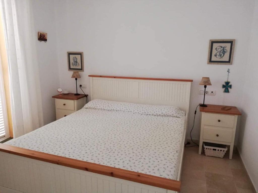 a bedroom with a bed and two night stands at Apartamento Ailem in Novo Sancti Petri