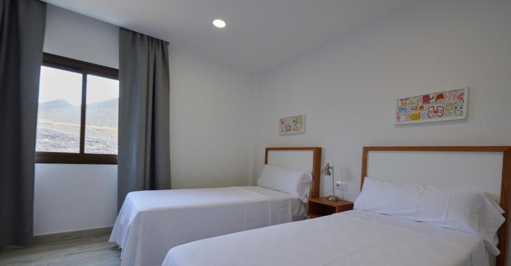 a hotel room with two beds and a window at ABLANCAS - La Restinga in La Restinga