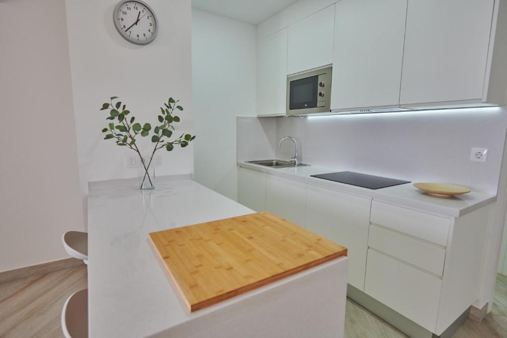 a kitchen with white counters and a clock on the wall at ABLANCAS - La Restinga in La Restinga