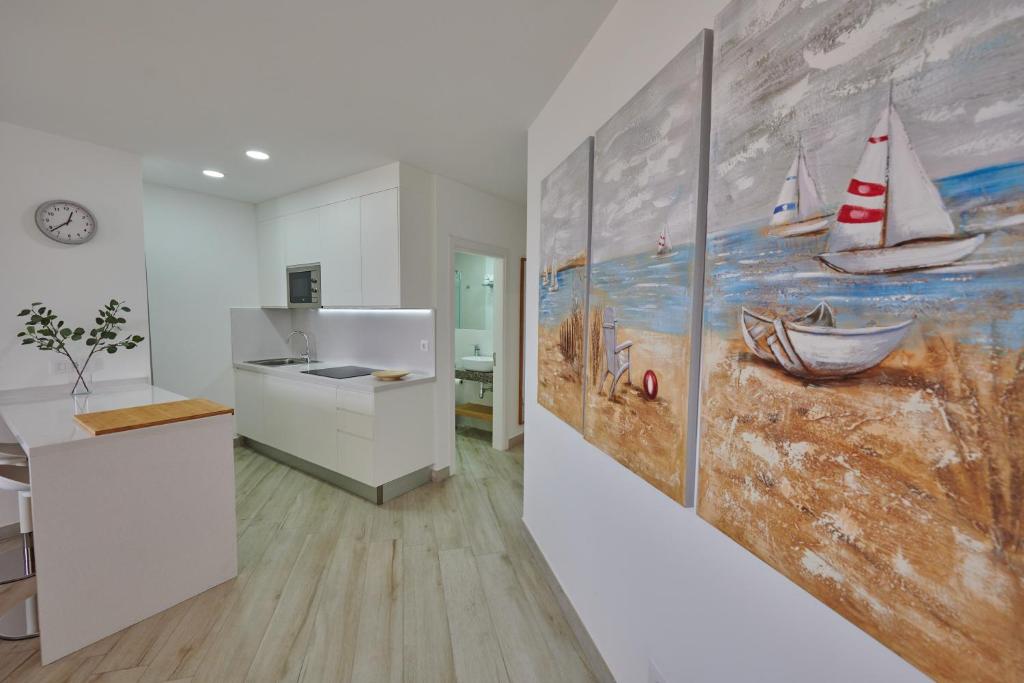 a kitchen with a painting of boats on the wall at ABLANCAS - La Restinga in La Restinga