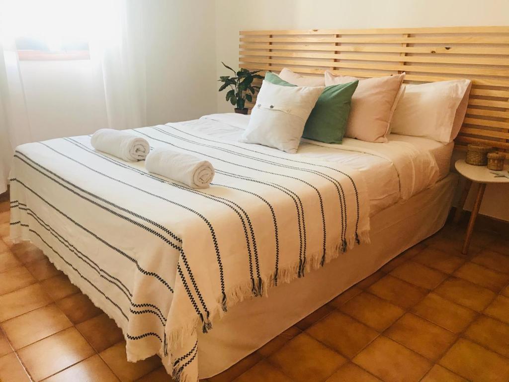 a large bed with white sheets and pillows at Casa 3 dormitorios Cala Galdana in Cala Galdana