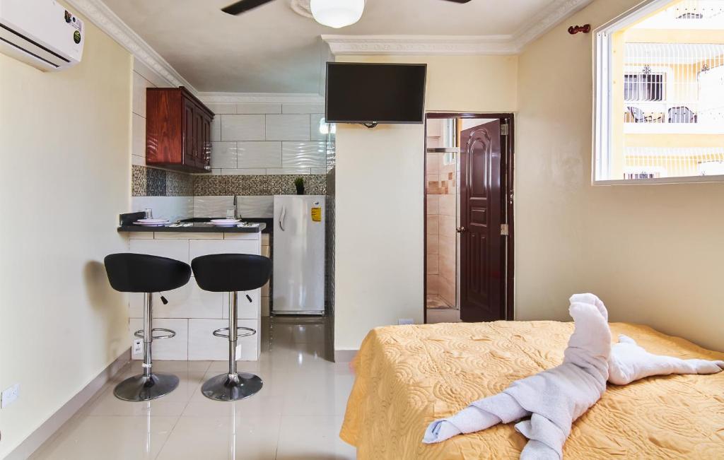 een kamer met een bed en twee krukken in een keuken bij Awesome Studio-apartment For 2 Near Las Americas Airport and Colonial Zone in La Viva