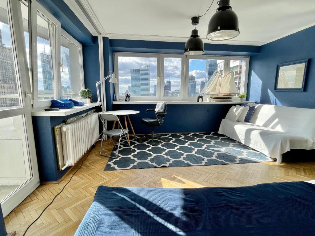 um quarto com paredes azuis, uma cama e uma secretária em Super Apartament BLUE Ścisłe Centrum Dwie Linie Metra Netflix WiFi 300 Mbs Panorama Miasta em Varsóvia