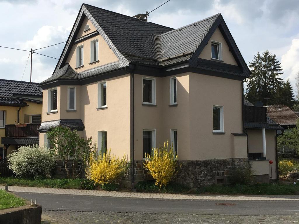una gran casa blanca con techo negro en Gästehaus VillaVerde, en Kelberg