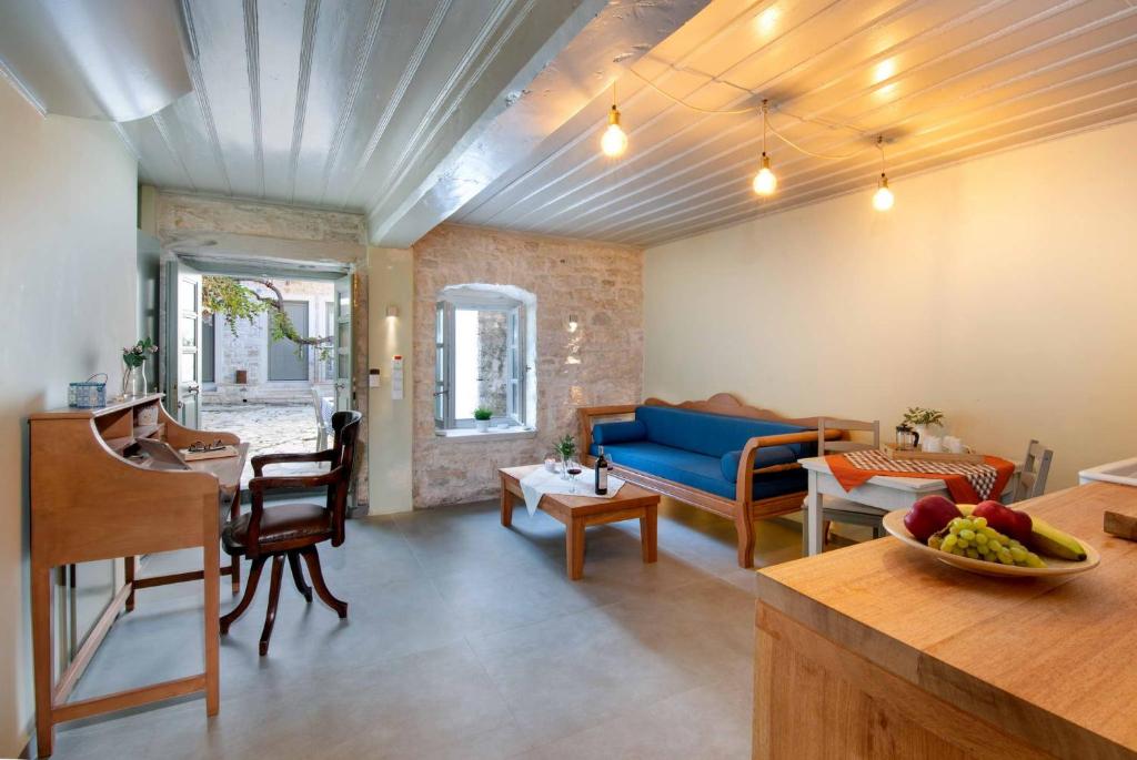 a living room with a blue couch and a table at Lakka Stone House 0 in Gaios