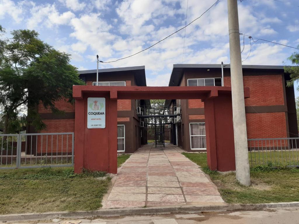 un edificio de ladrillo rojo con una puerta delante de él en COQUENA Departamentos en La Rioja