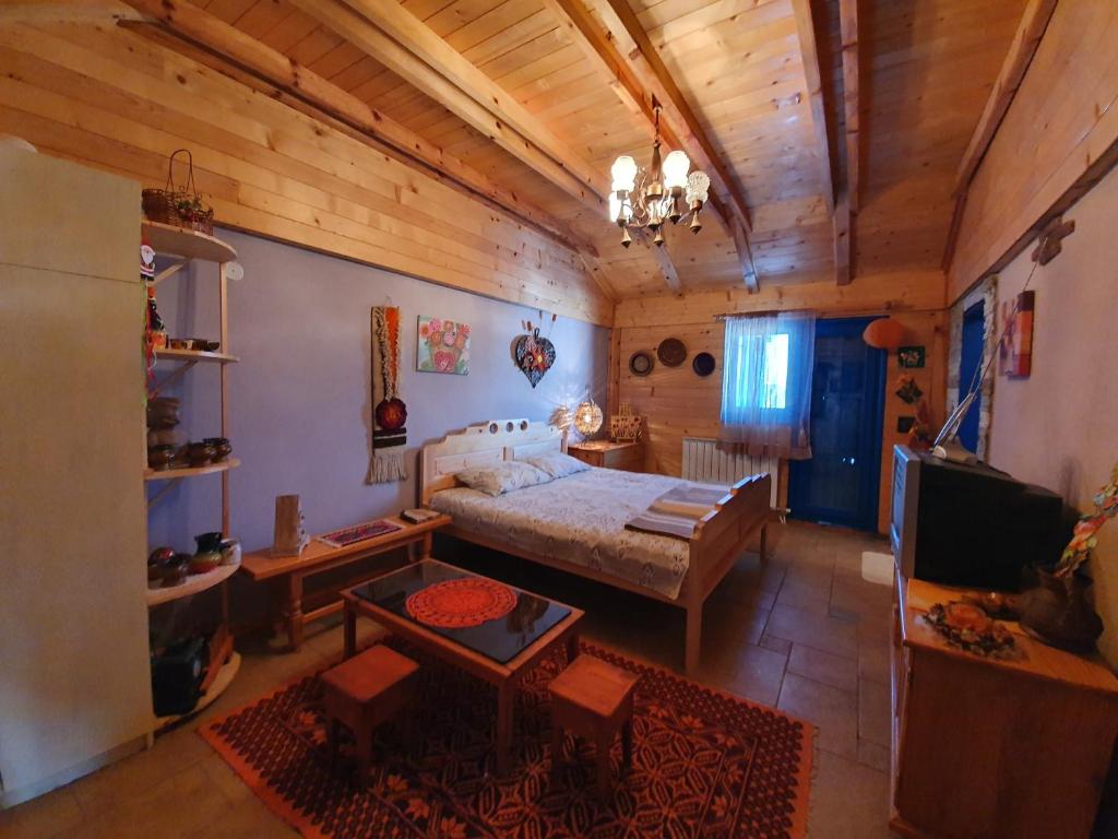 a bedroom with a bed and a living room at Ethno Homestay Savić in Vodice