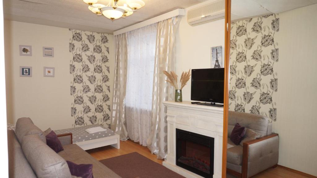 a living room with a couch and a fireplace at Kremlyovskaya Apartament in Vladimir