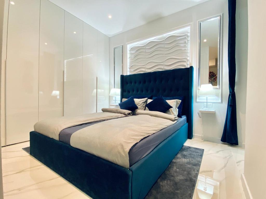 un letto blu in una camera bianca con finestra di Studio Six a Umag (Umago)