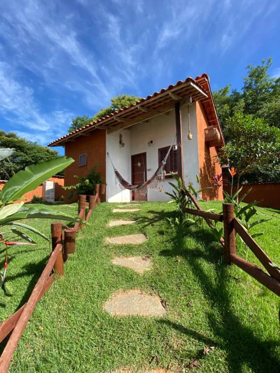 uma casa com uma cerca em frente em Chalés na Roça em Pirenópolis