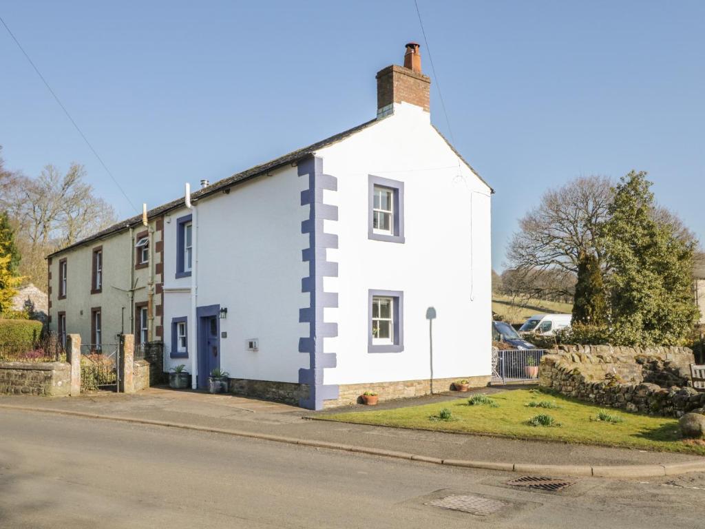 a white house on the side of a street at Beckside Cottage in Welton