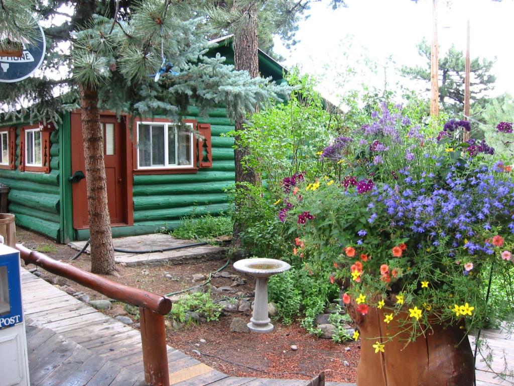 Riverbend Resort في ساوث فورك: حديقة فيها ورد امام بيت اخضر