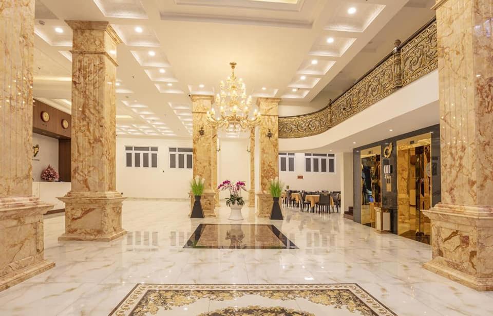 un gran vestíbulo con columnas y una lámpara de araña en Mai Vang Hotel, en Da Lat