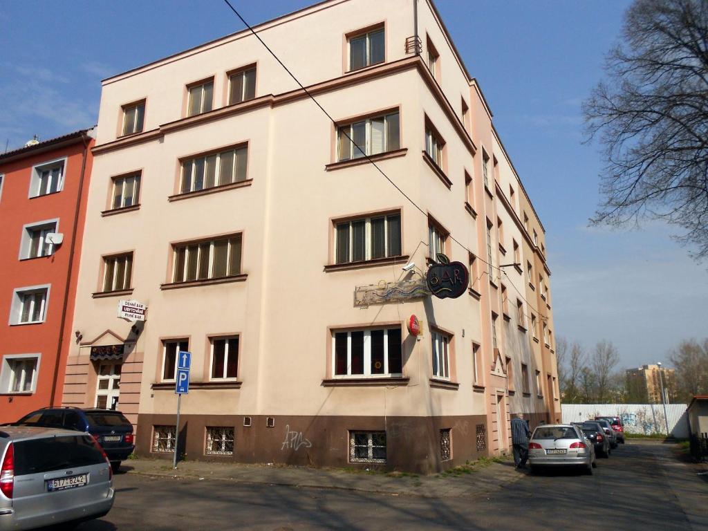 ein hohes weißes Gebäude mit davor geparkt in der Unterkunft Penzion Paradise in Ostrava