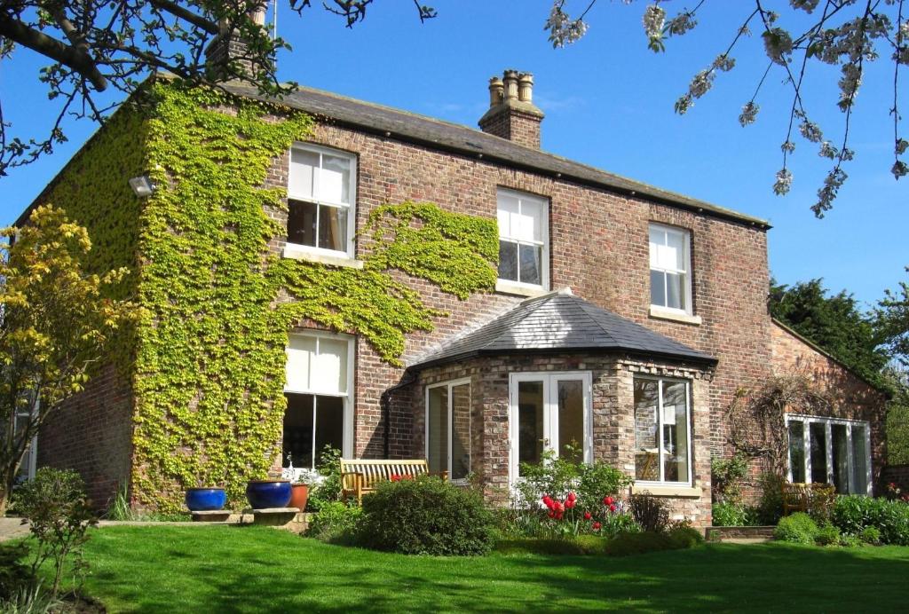 a brick house with ivy growing on it at Marton Grange Country House in Bridlington