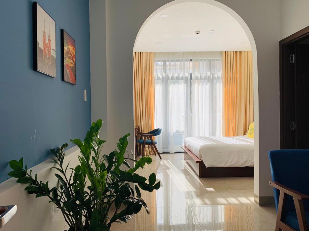 1 dormitorio con 1 cama y 1 habitación con planta en Chez Mimosa Petite - Free Laundry, en Ho Chi Minh