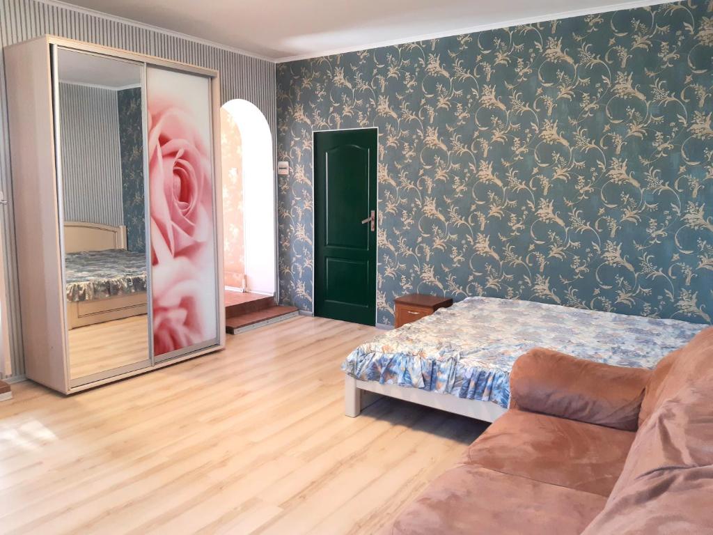 a bedroom with a bed and a couch in a room at Яновского 2к in Kropyvnytskyi