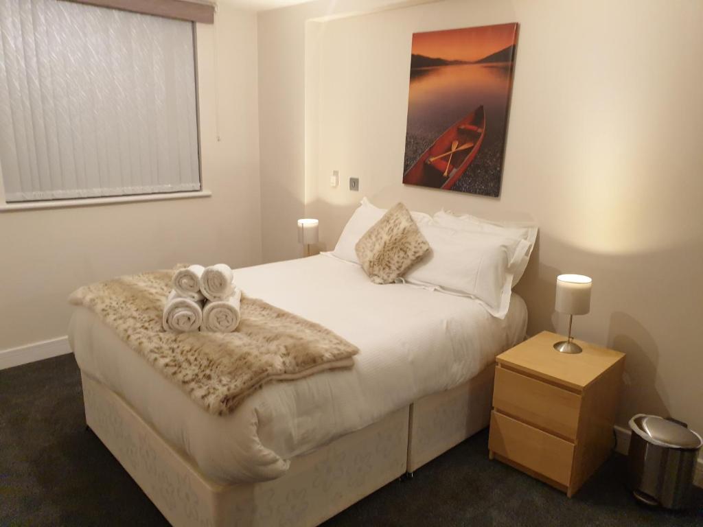 Birmingham Garnet, 3 bedroom Apartment في برمنغهام: غرفة نوم عليها سرير وفوط