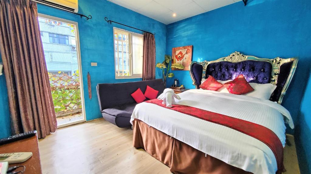 礁溪鄉的住宿－笑笑魚溫泉民宿，蓝色的卧室设有一张大床和一张沙发