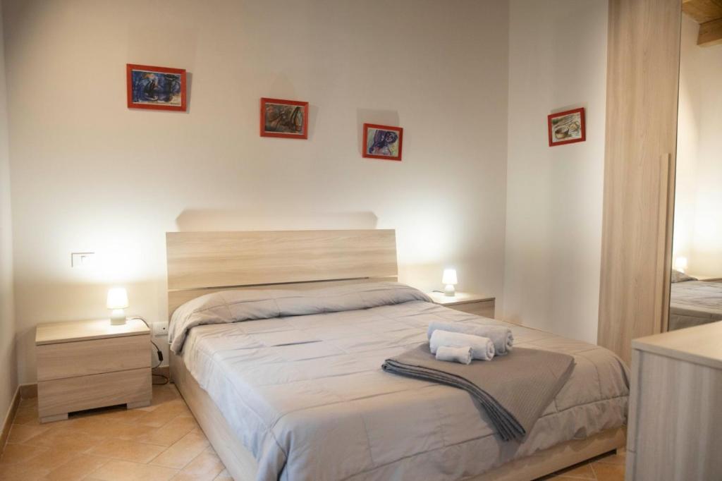 um quarto com uma cama grande com duas toalhas em Cavallotti em Sassari