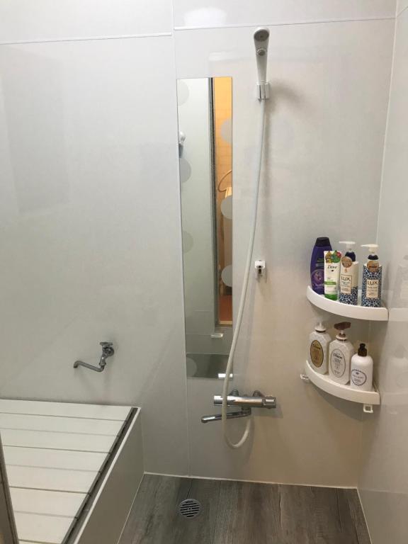 a bathroom with a shower with a glass door at Bonel Guest House in Tomisato