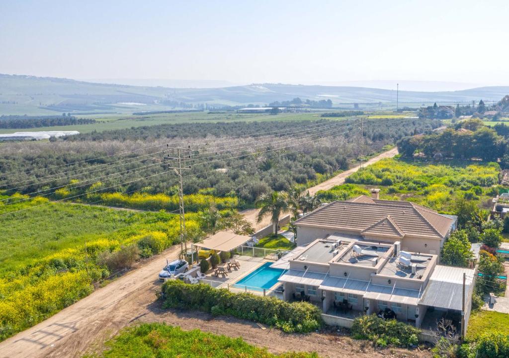an aerial view of a house with a swimming pool at Zimmer BaSadot in Yavneʼel