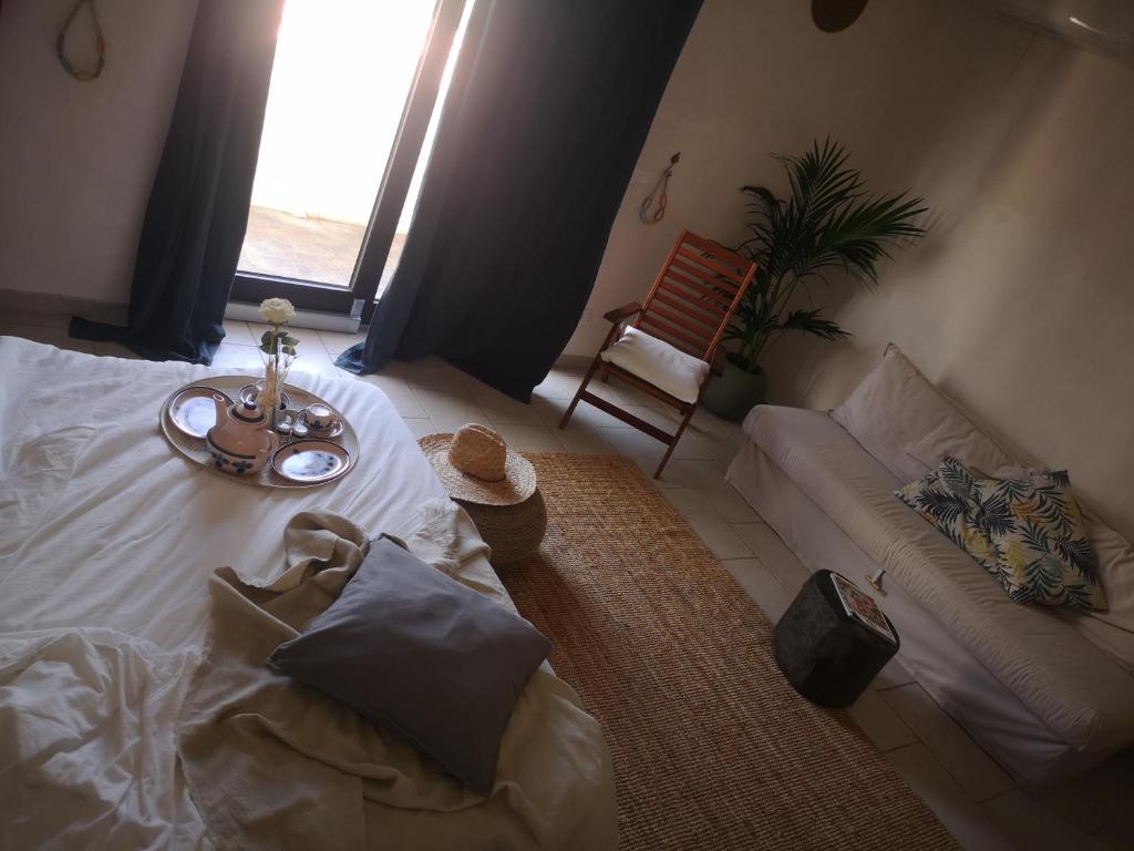 ein Schlafzimmer mit einem Bett mit einem Tisch und einem Sofa in der Unterkunft B&b Villa Rosalia in Procida