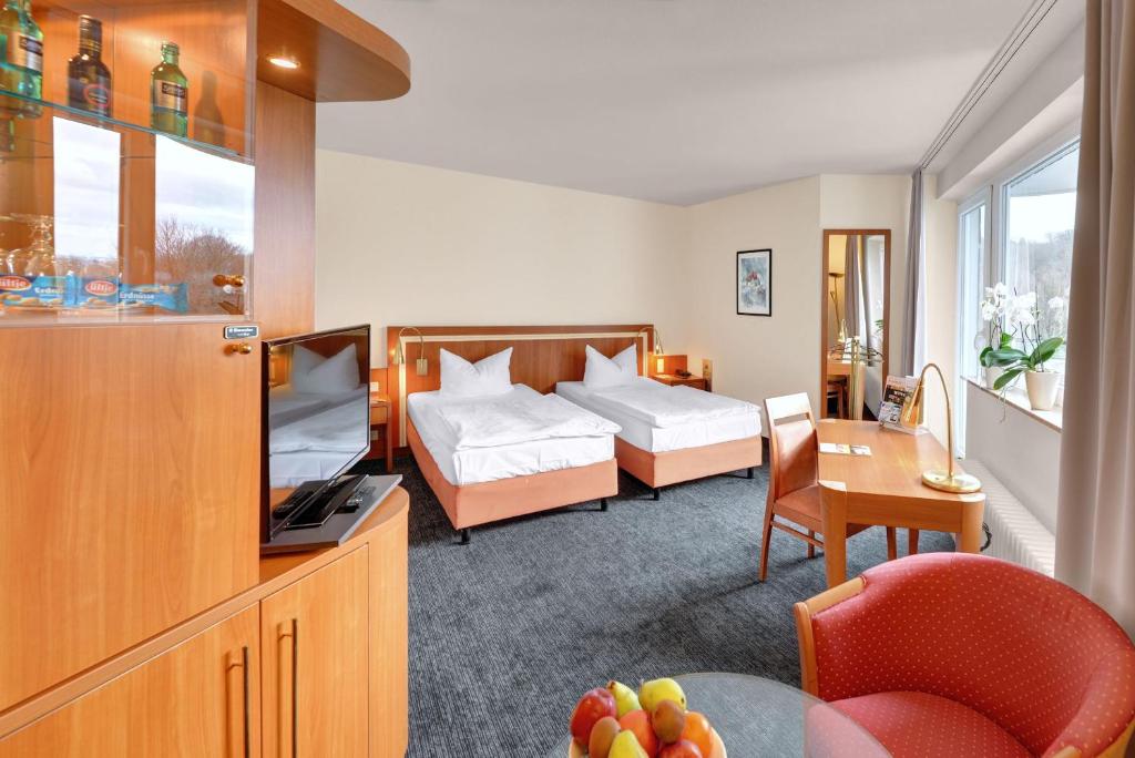 a hotel room with a bed and a television at Ringhotel Parkhotel Witten in Witten