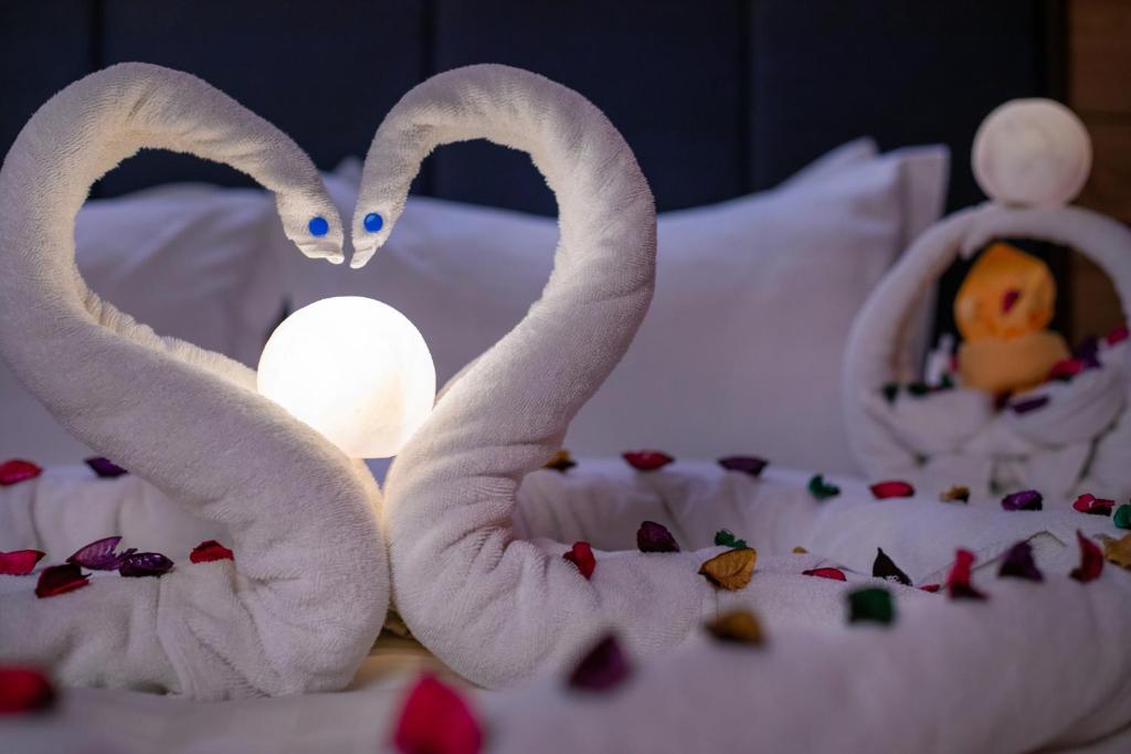 dos toallas con forma de cisnes sentados en una cama en Lavent Park en Yeda