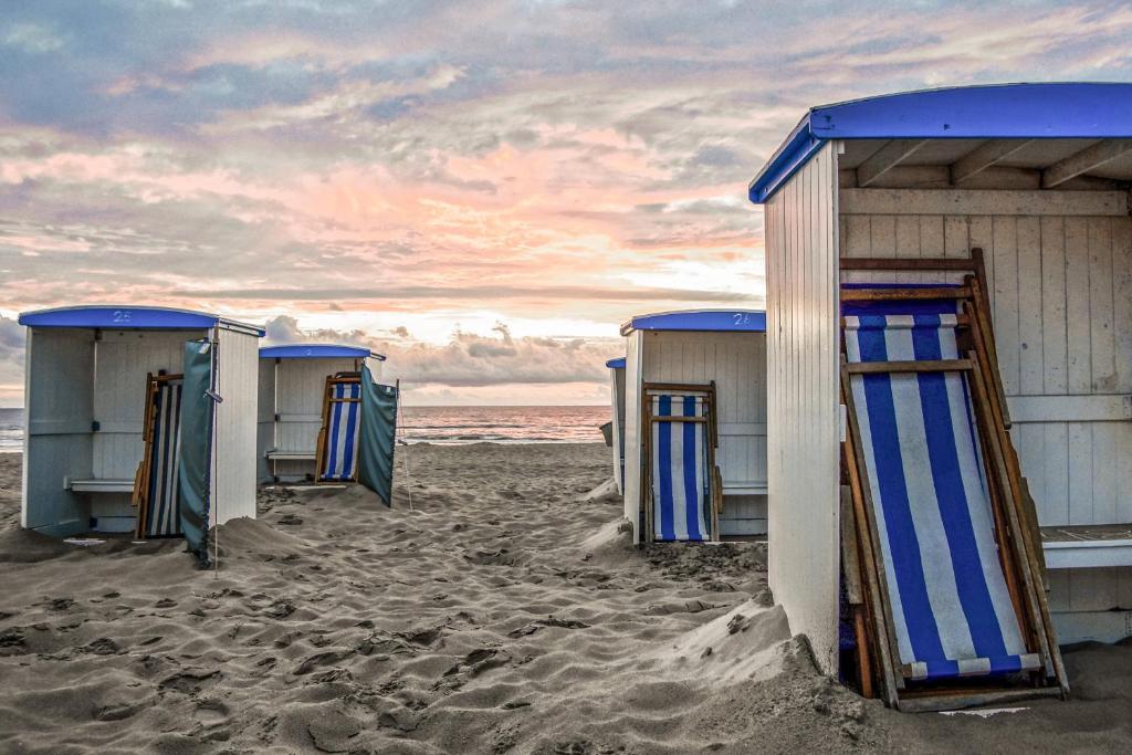 a row of beach huts on the beach at Appartement 5 in Katwijk aan Zee