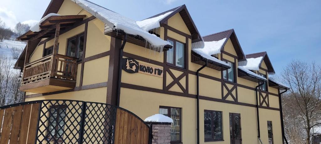 une maison avec de la neige sur le toit dans l'établissement Коло Гір, à Kolochava
