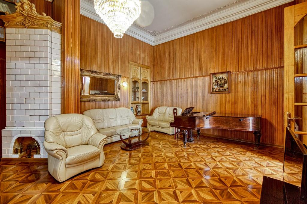 - un salon avec un piano, un canapé et des chaises dans l'établissement Town Center Rustaveli ApartHotel, à Tbilissi