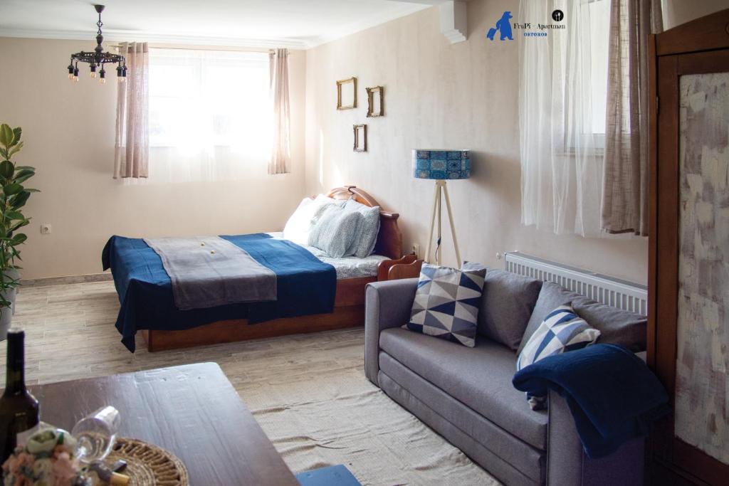 a living room with a couch and a bed at FruPi-Apartmanok in Ostoros