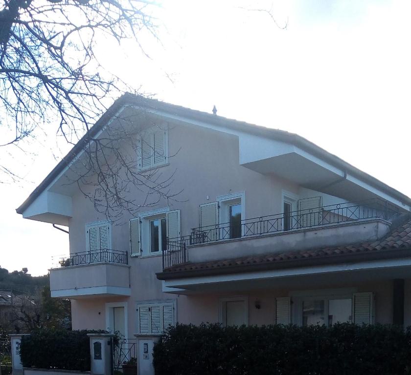Una gran casa blanca con balcones en un lateral. en B&B IL NIDO en Cattolica