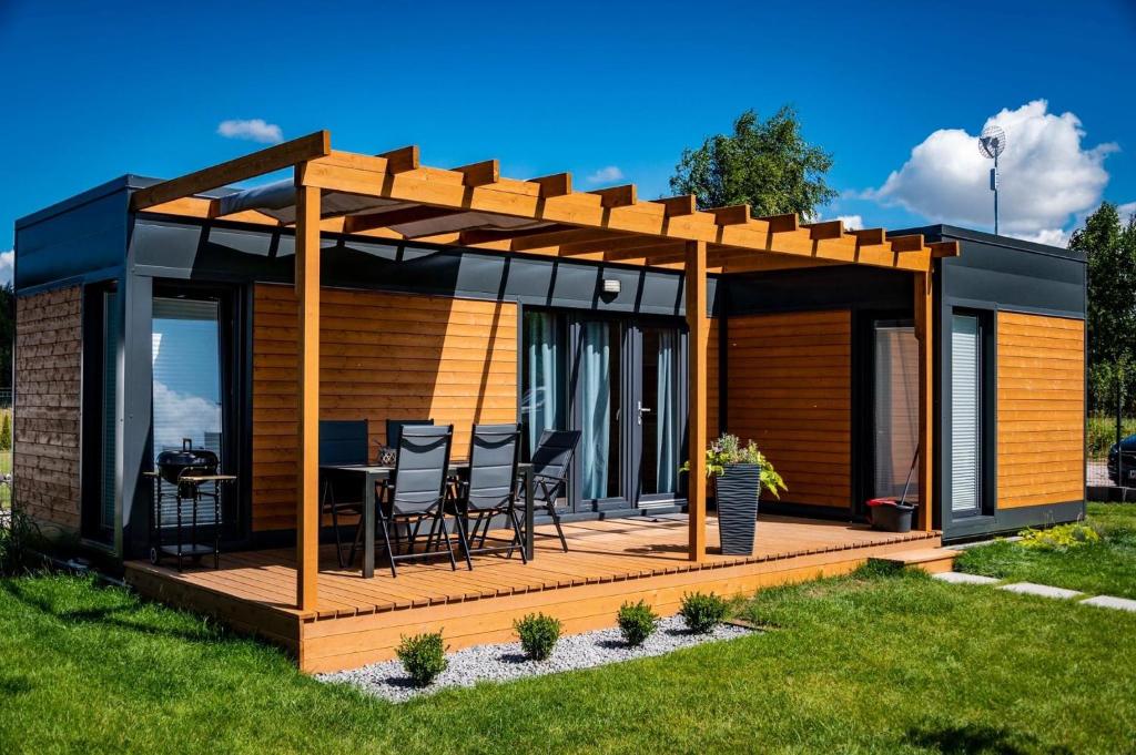 a house with a deck with a pergola at Twoje Rydzewo in Rydzewo