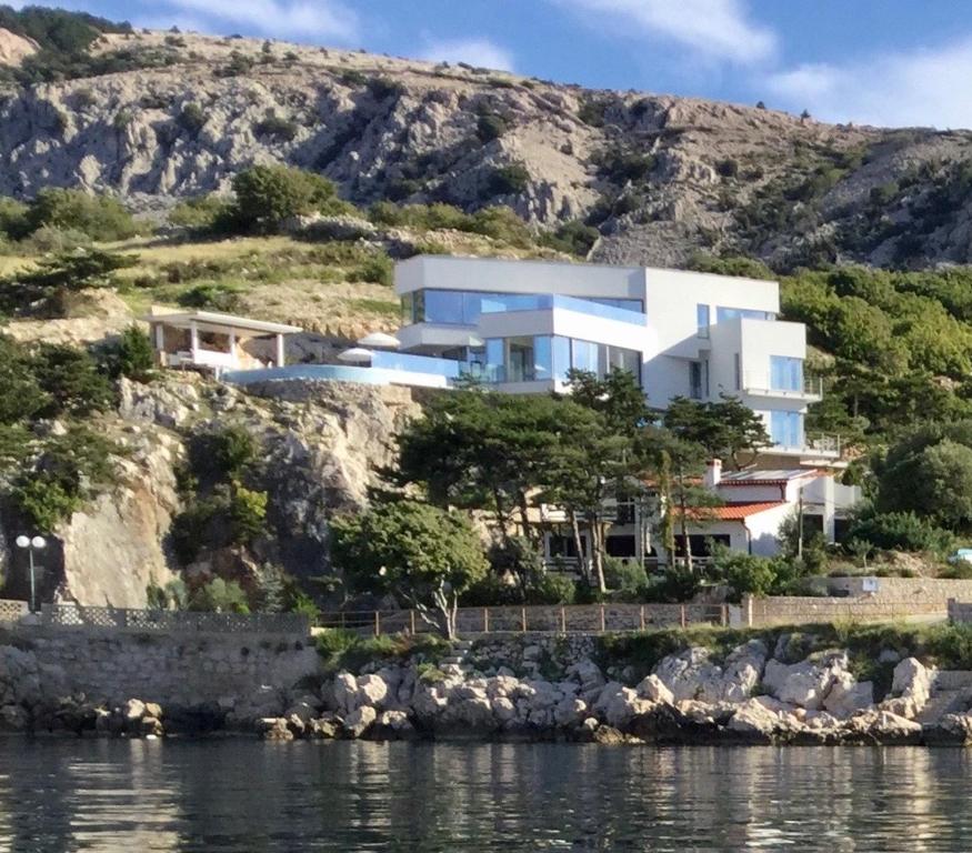 a house on a hill next to the water at Shimmer & Shine in Baška