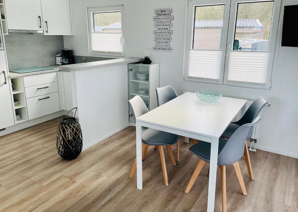 a kitchen with a white table and chairs at Beach Chalet SunHus - modernes Chalet in Ostseenähe in Scharbeutz