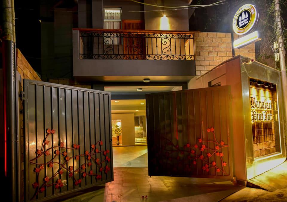 un edificio con una puerta con flores rojas. en BANALARI PINE INN en Shillong