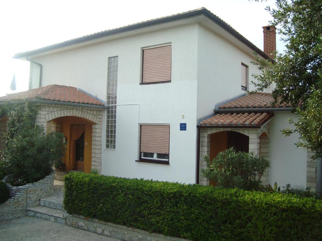 a white house with a red roof at Studio apartman in Omišalj