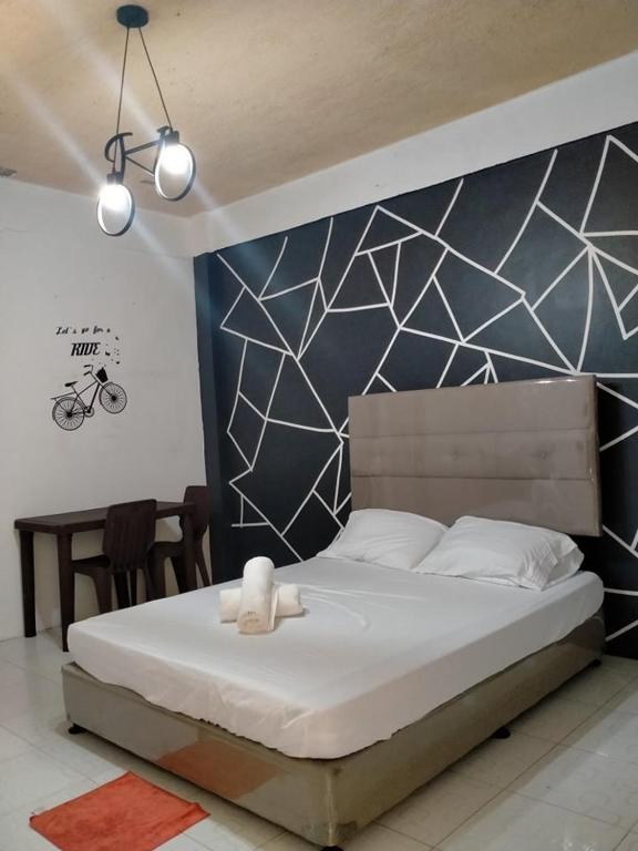 a bedroom with a large white bed with a wall at DJCI Apartelle Walk to Robinson & NE Pacific Mall 3 Min to SM Cabanatuan in Cabanatuan