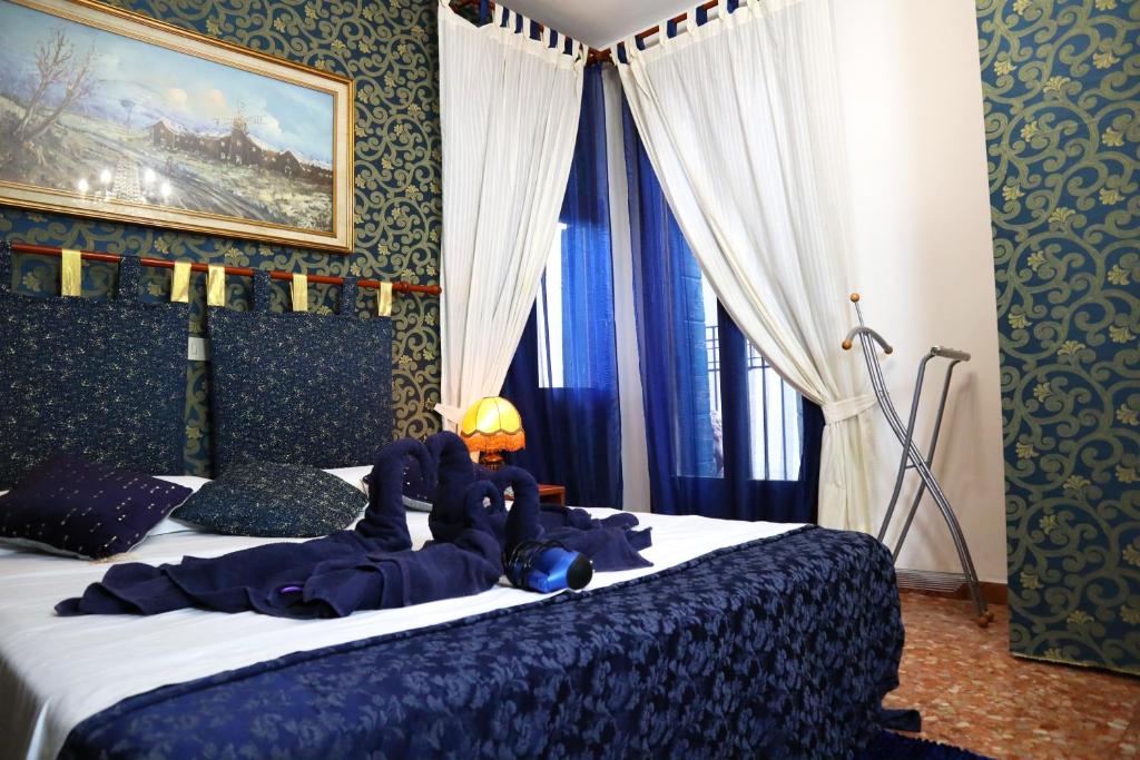 1 dormitorio con 1 cama con sábanas y cortinas azules en VENICE RAINBOW APARTMENT (RIALTO) en Venecia